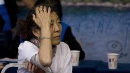A woman, right, one of the relatives of Chinese passengers aboard the missing Malaysia Airlines flight MH370, sits near volunteers from Malaysia as she attends a briefing by Malaysian officials at a hotel in Beijing Sunday, March 30, 2014. Several dozen Chinese relatives of passengers on Flight 370 demanded Sunday that Malaysia apologize for its handling of the search for the missing plane and for the prime minister's statement saying it crashed into the southern Indian Ocean. (AP Photo/Andy Wong)