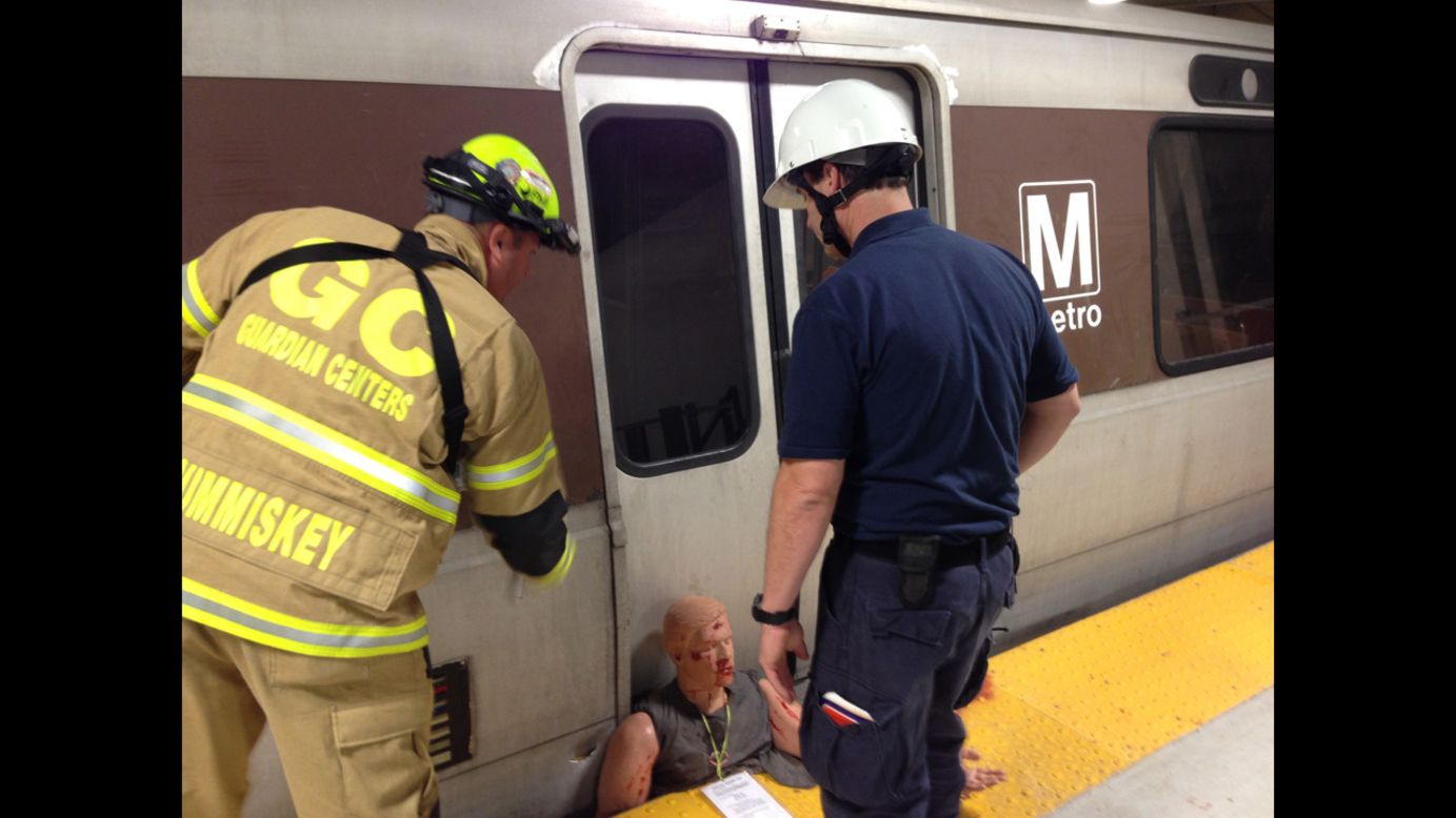 Responders work at the scene of a mock subway accident.