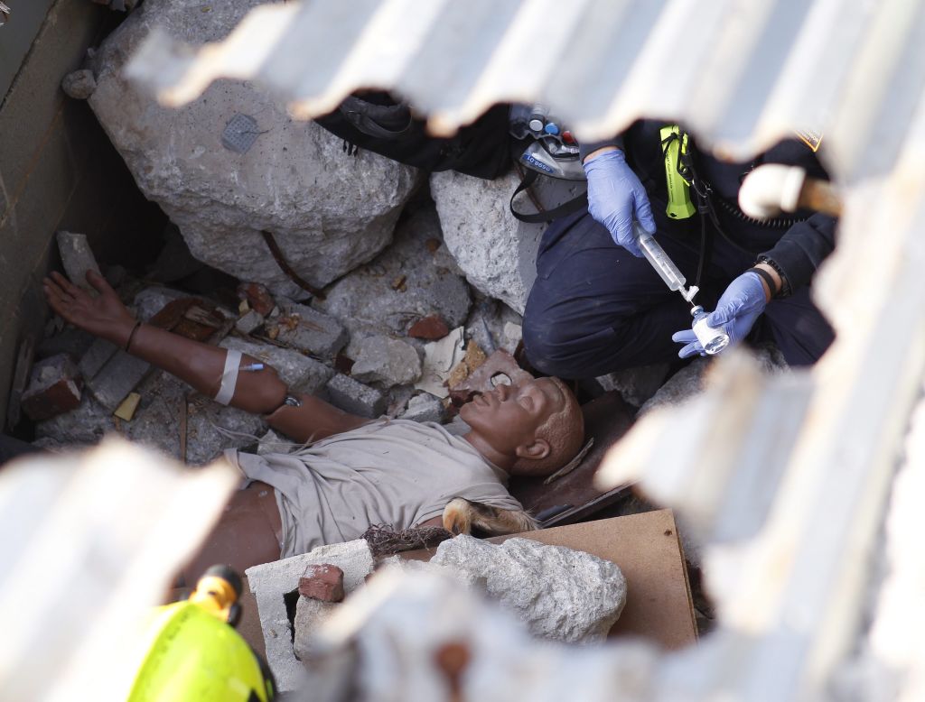 A Task Force member works on a dummy victim during a mock steel building collapse.