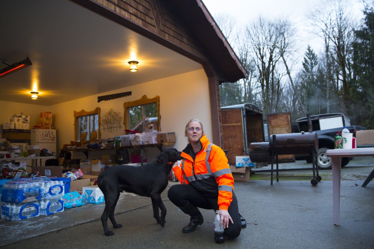 Elaine Young of Oso, Washington, pets her dog at a home used as a staging area for donated food and supplies. 