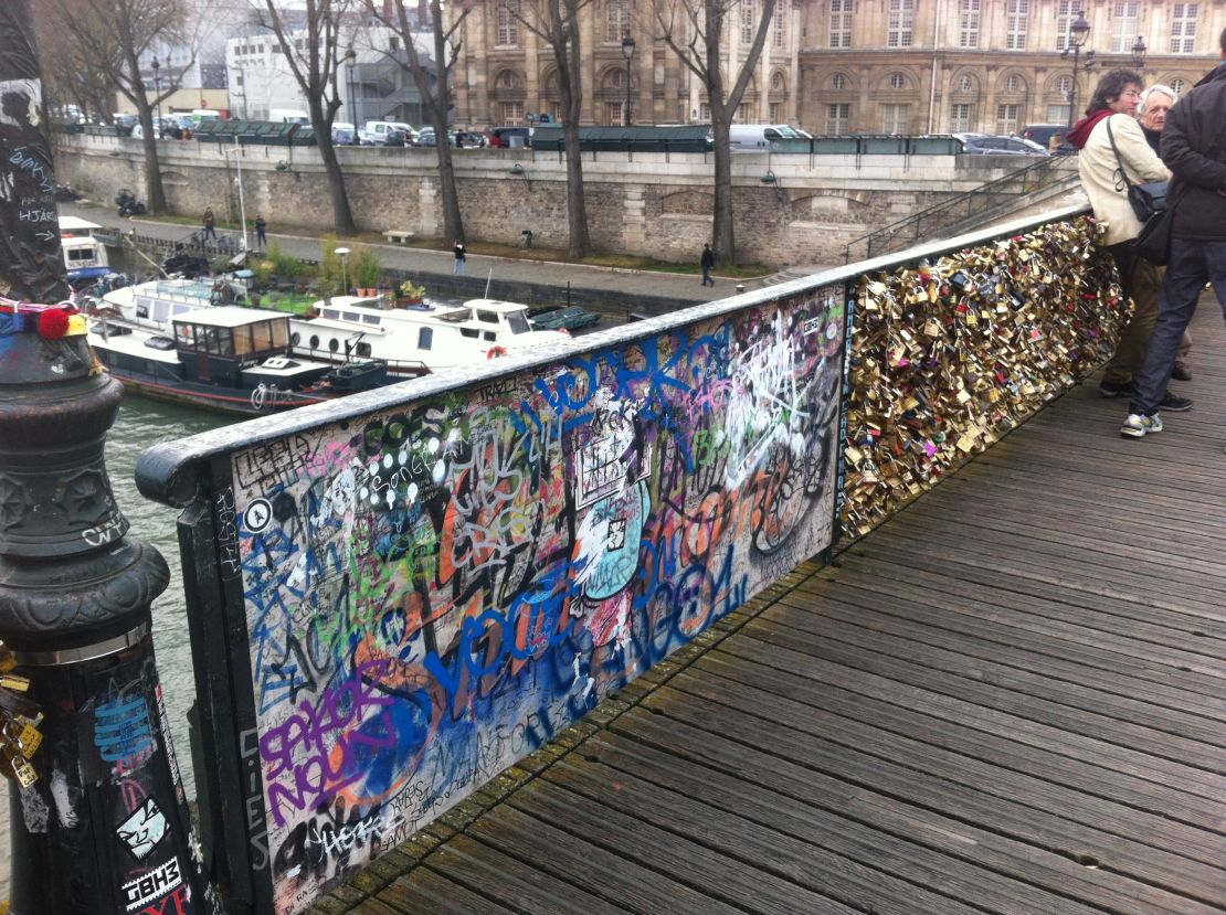 Sections of the bridge damaged by locks have been replaced by unsightly wooden panels.