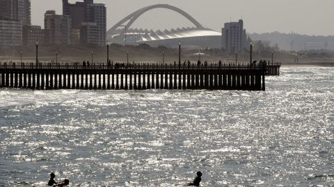 Surfers take to the Indian Ocean, with the Moses Mabhida Stadium - which hosted 2010 World Cup matches - in the background. 