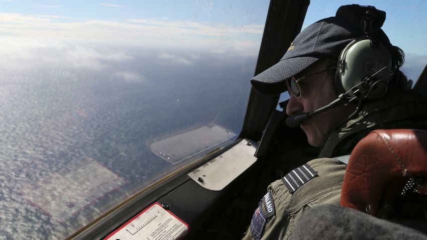 Royal New Zealand Air Force P3 Orion captain Wing Commander Rob Shearer looks out of the window of his aircraft while searching for missing Malaysia Airlines flight MH370, over the Indian Ocean on March 31, 2014.  No time limit will be imposed on the search for MH370 because the world deserves to know what happened, Australian Prime MinisterTony Abbott said, as a ship equipped to locate the plane's "black box" prepared to set sail.    AFP PHOTO / POOL / Rob GRIFFITH        (Photo credit should read ROB GRIFFITH/AFP/Getty Images)