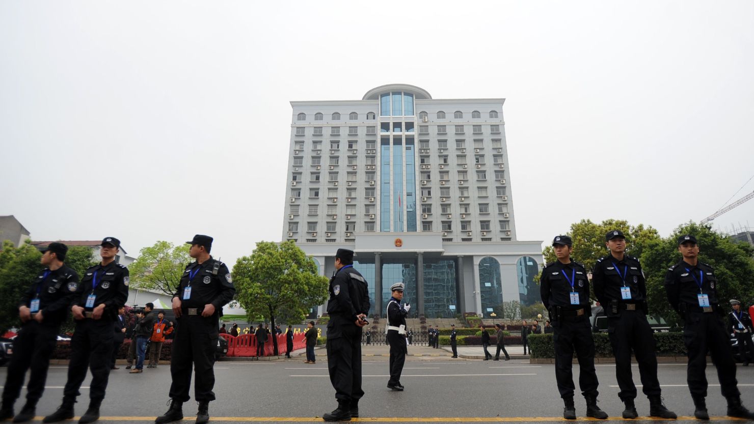 Police stand guard outside the Xianning Intermediate People's Court, where mining tycoon Liu Han stands trial for charges including murder.