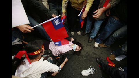 A supporter of the trade pact faints during clashes between protesters and police April 1 in Taipei.