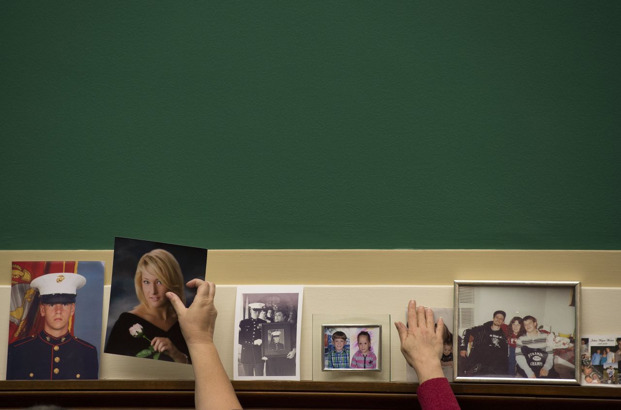 Family members place pictures of their loved ones on the committee wall before the hearing on Capitol Hill.