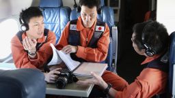 Observers on a Japan Coast Guard Gulfstream aircraft discuss their mission brief before they begin searching for wreckage and debris of missing Malaysia Airlines Flight MH370 in the Southern Indian Ocean on April 1, 2014. Malaysia revealed the full radio communications with the pilots of its missing flight on April 1, but the routine exchanges shed no light on the mystery as an Indian Ocean search for wreckage bore on with no end in sight. AFP PHOTO / POOL / Rob GRIFFITH (Photo credit should read ROB GRIFFITH/AFP/Getty Images)