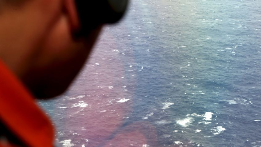 AT SEA - APRIL 01: Kazuhiko Morisawa of the Japan Coast Guard looks out of a window of the Japan Coast Guard Gulfstream aircraft searching for wreckage and debris of missing Malaysia Airlines Flight MH370 in Southern Indian Ocean on April 1, 2014 near Australia. Bad weather and poor visibility caused the search to be called off early with the coast guard plane only completing one of its three 210 nautical mile legs. (Photo by Rob Griffith - Pool via Getty Images)
