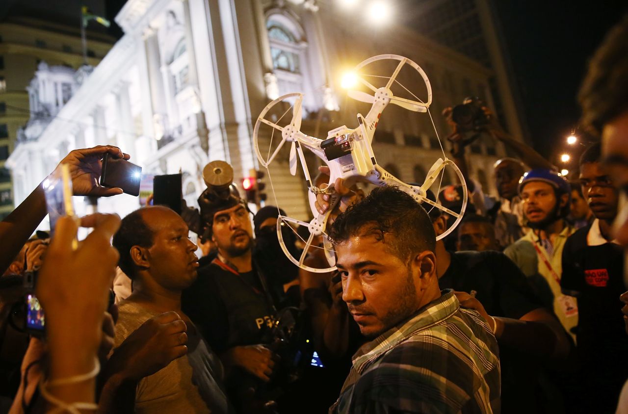 Protesters question a man who was operating a quadcopter drone with camera during February's protests in Rio. 