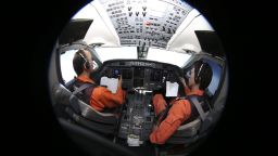 Captain of the Japan Coast Guard Gulfstream Makato Hoshi (L) and his co-pilot Shunichi Yumiza sit in the cockpit during the search for missing Malaysia Airlines flight MH370 over the southern Indian Ocean on April 1, 2014