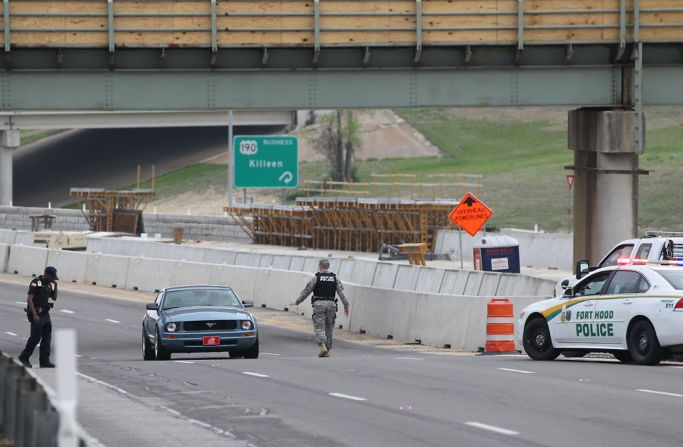 A military police officer stops a car.