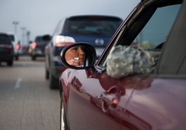 Lt. Savanah Hess, a nurse, waits in her car to enter the locked-down post.