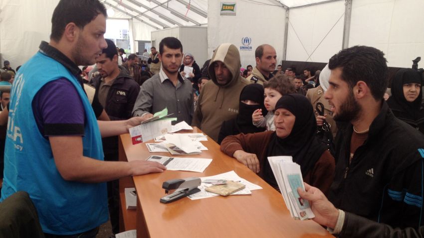 Syrian refugees queue at a UNHCR (United Nations Refugee Agency) registration center in Tripoli on April 3, 2014.