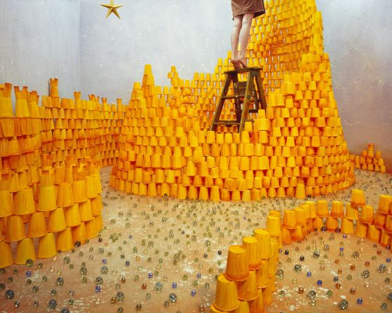 In this image, over 2,000 hand-painted paper cups are stacked together as bricks of a fragile castle. Lee explains: "I wanted to express the process of heading toward your desire, along with the effort it takes to achieve your dream, which is represented by the star." The glass marbles spread on the floor symbolize fallen stars.