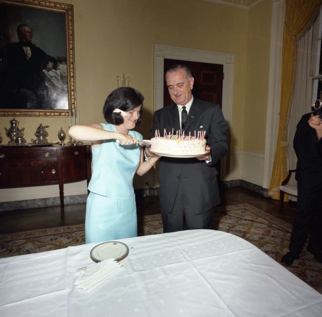 Luci Baines, with her father helping out, cuts her 17th birthday cake. On that day, LBJ signed the 1964 Civil Rights Act, which she calls "the best birthday present anyone could ever receive."