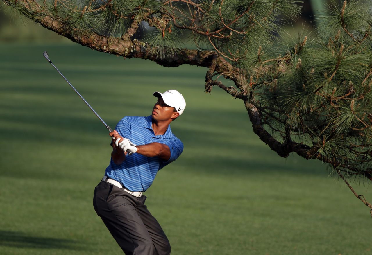 Tiger Woods plays a shot under the Eisenhower Tree at the 2011 Masters, suffering an injury that would cause him to miss four months of the season. 