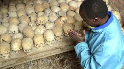 A Rwandan survivor of the 1994 Genocide prays over the bones of genocide victims at a mass grave in Nyamata, Rwanda, in this April 6, 2004 file photo.