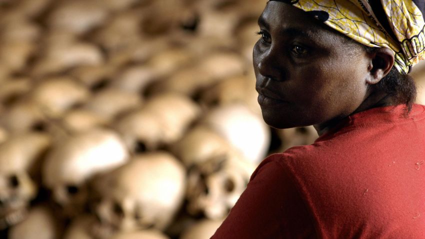 Genocide memorial site guardian, Danielle Nyirabazungu, rests 27 February 2004 close to the skulls of the people killed during the 1994 genocide in the church of Nyamata, Rwanda.