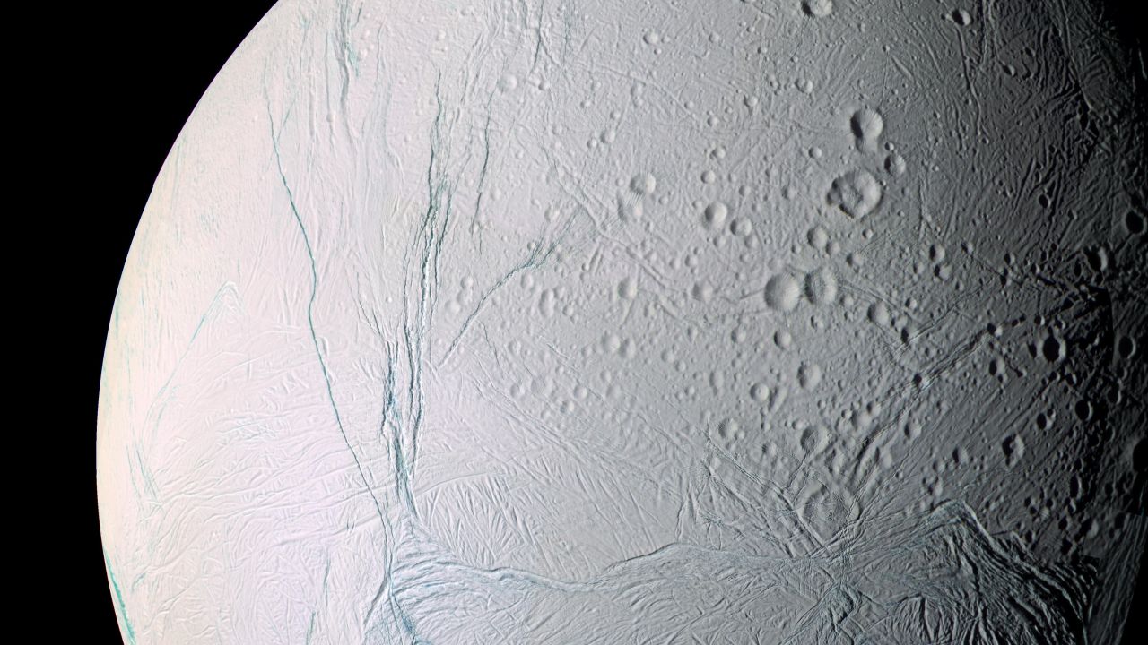 The scars of time and space mark the surface of Saturn's moon Enceladus. Saturn has at least 62 moons in its orbit. 