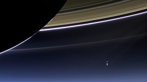 The small bright dot seen in the bottom right is not another Saturn moon. It's Earth. The distance between Saturn and our planet is constantly changing because both are constantly in motion. When they are closest together during their orbits, Saturn is 746 million miles away from Earth. At its farthest, they are just over a billion miles apart. <a href="http://www.cnn.com/2014/06/27/tech/gallery/cassinis-top-discoveries/index.html" target="_blank">See Cassini's top 10 discoveries about Saturn</a>