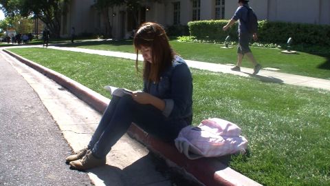 On her school campus, Saira Murillo reads before heading to class. 