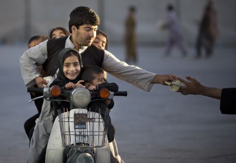 Niedringhaus had worked in the region for over 20 years. In this photo, she shows an Afghan man with his five children on his motorbike, paying money to enter a park in Kandahar.