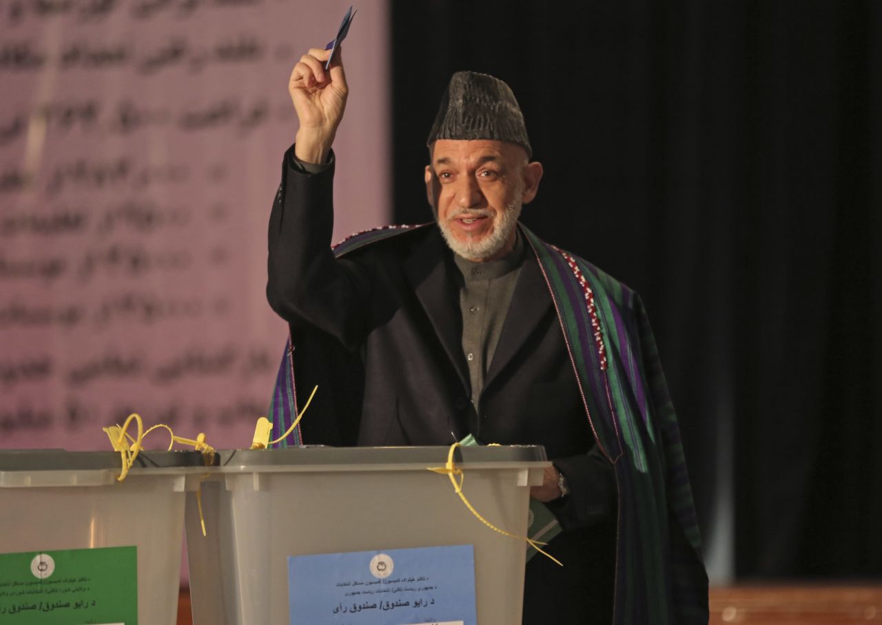President Hamid Karzai shows his ballot to the media before he casts his vote at Amani High School, near the presidential palace in Kabul.