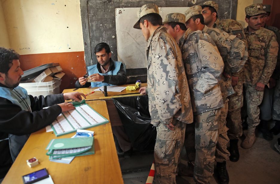 Afghan security personnel line up for registration before voting at a polling station in Kabul.