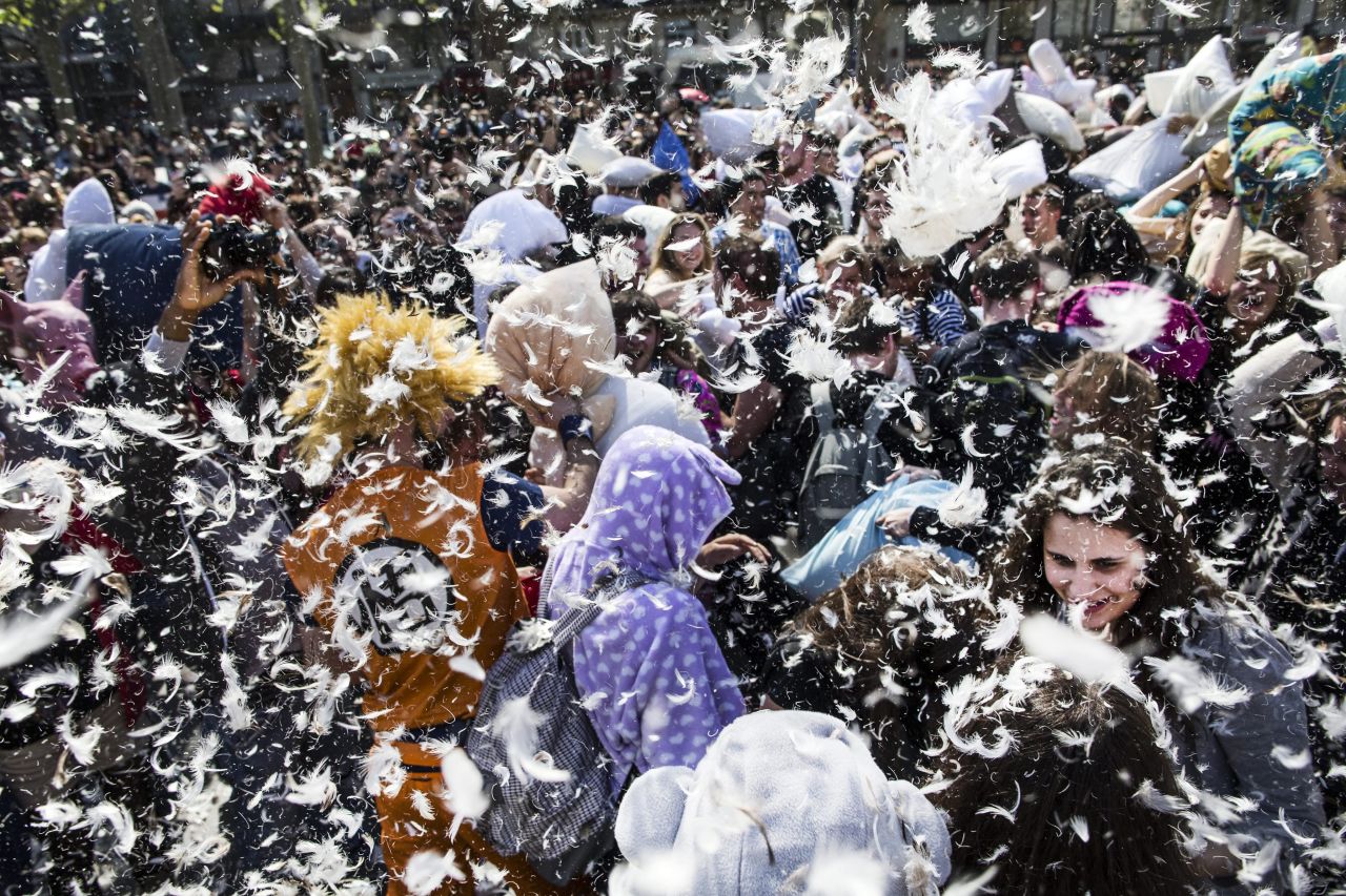 A cloud of feathers hangs over those participating in International Pillow Fight Day in Paris on Saturday, April 5. The event takes place in dozens of cities around the world.