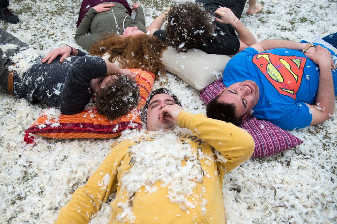 People rest on the ground with their weapons on a bed of feathers during the fight at the Westpark in Berlin.