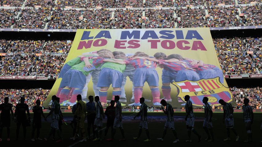 Barcelona's supporters unveil a giant banner reading in Catalan 'La Masia, don't touch it' before the Spanish league football match FC Barcelona vs Real Betis at the Camp Nou stadium in Barcelona. AFP PHOTO / JOSEP LAGO (Photo credit should read JOSEP LAGO/AFP/Getty Images