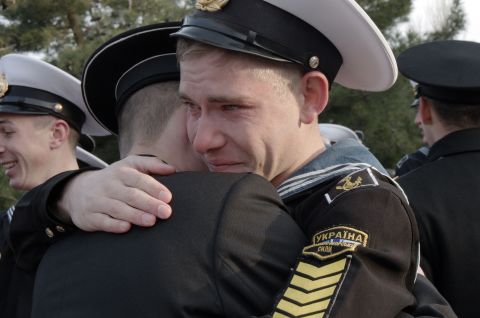Ukrainian cadets at the Higher Naval School embrace a friend who has decided to stay in the school during a departure ceremony in Sevastopol, Crimea, on Friday, April 4. Some 120 cadets who refused to take Russian citizenship left the school to return to Ukraine.