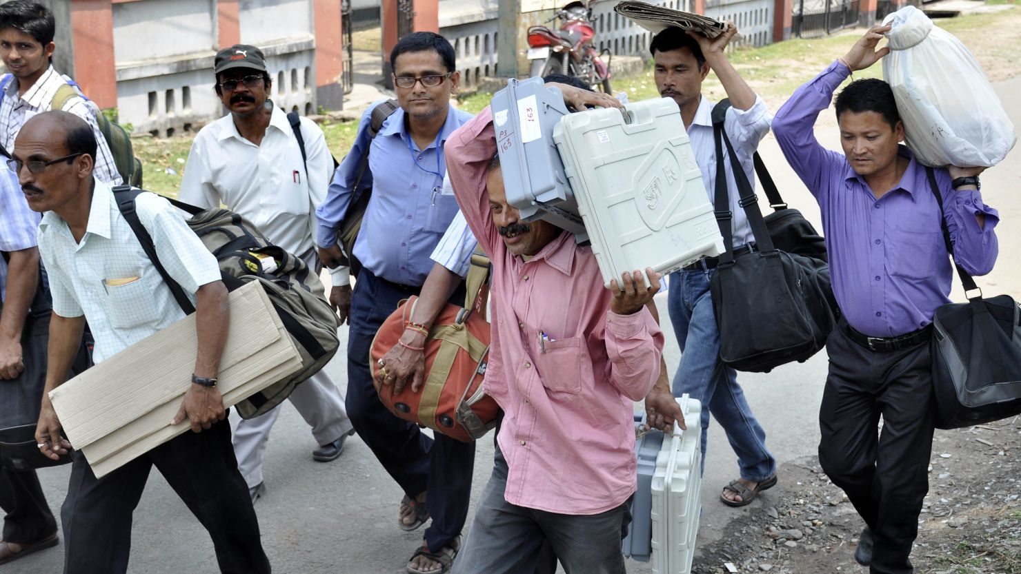 Poll officials carry voting machines in Nagaon, Assam, on Sunday in preparation for the national election. 