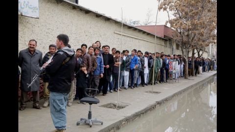 Men line up to vote outside a polling station in Kabul on April 5, 2014.