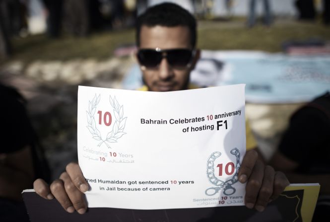 A Bahraini photographer holds a placard to express solidarity with jailed colleague Ahmed Humaidan during the protest at Shakhurah.