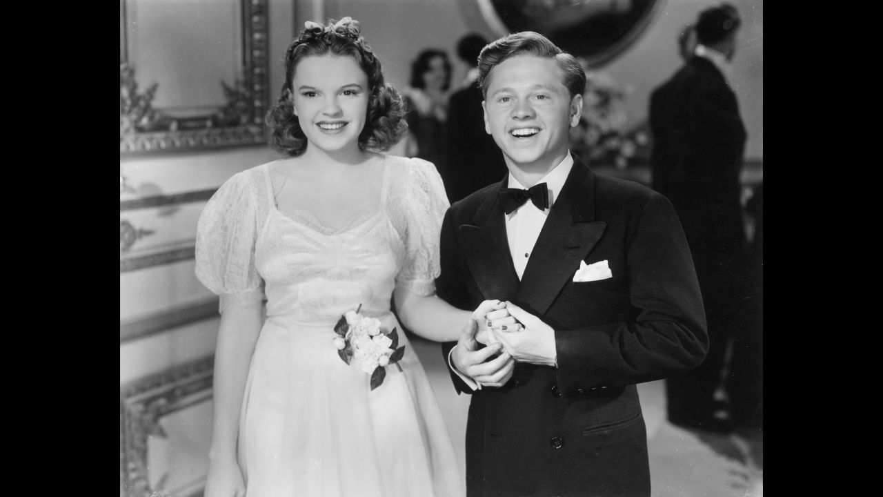 Rooney hold hands with Garland in a 1940 still from the film "Andy Hardy Meets Debutante."