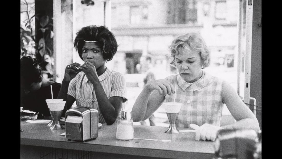 A black woman and a white woman sit next to each other at a New York City restaurant in 1962.