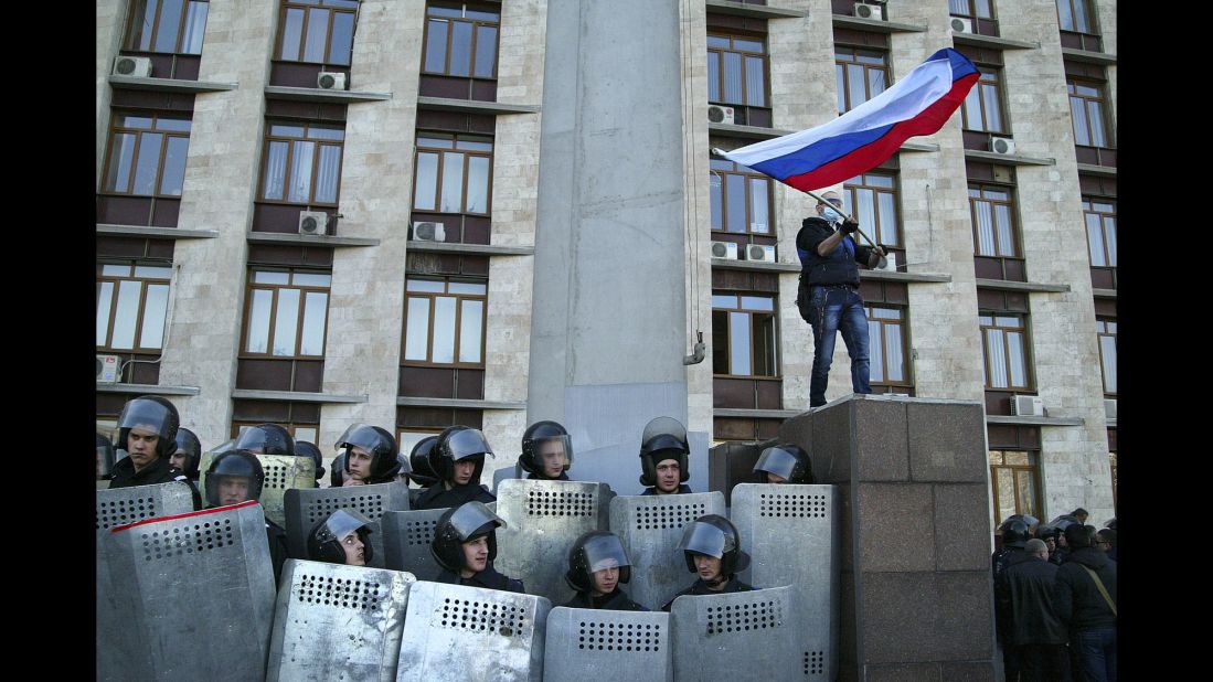 Protesters wave a Russian flag as they storm the regional administration building in Donetsk on Sunday, April 6. Protesters seized state buildings in several east Ukrainian cities, prompting accusations from Kiev that Moscow is trying to "dismember" the country.