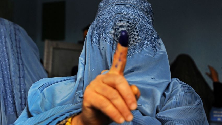 An Afghan woman shows her inked finger after voting at a polling station in the northwestern city of Herat on April 5, 2014.