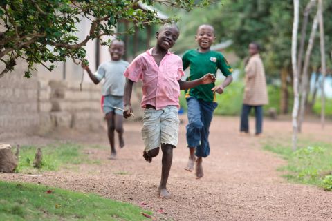 Boys run through the village of Pelewahun, Sierra Leone. Without shoes, they're at high risk for infection with soil-transmitted helminths like hookworm.