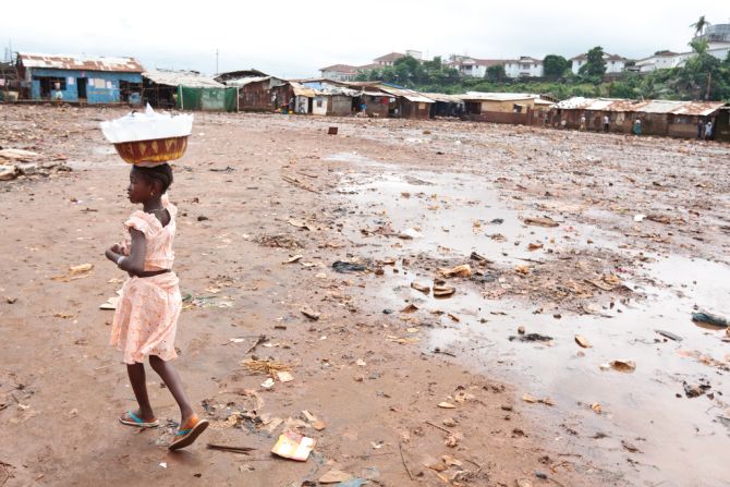 People living in poverty, without access to clean water and sanitation have the highest risks of infection with intestinal worms. A girl carries plastic bags of drinking water she sells in the Kroo bay slum of Freetown, Sierra Leone. 