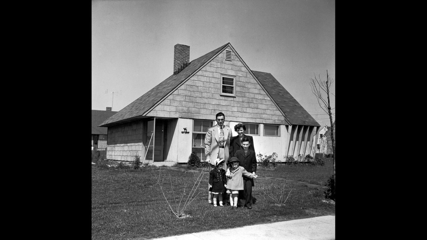 Truck supervisor Bernard Levey with his family in front of their new home in 1950. The post-war period was a prosperous time for middle-class Americans. 