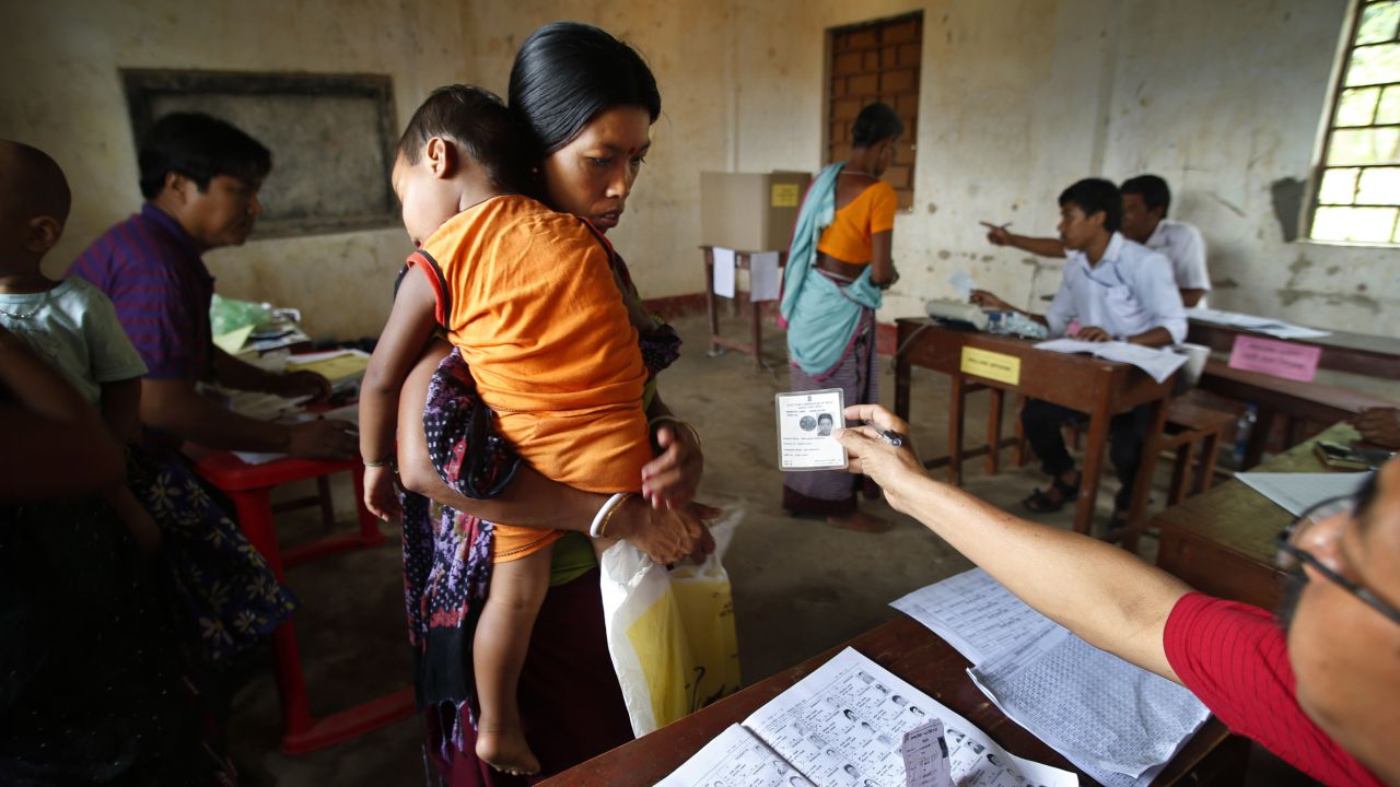 An official checks a voter's identity card in Agartala, India, on Monday, April 7.