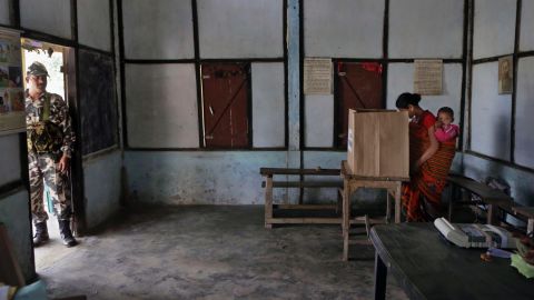 A woman with a baby casts her vote inside a polling center at Misamora Sapori, an island in the Brahmaputra River, on April 7.
