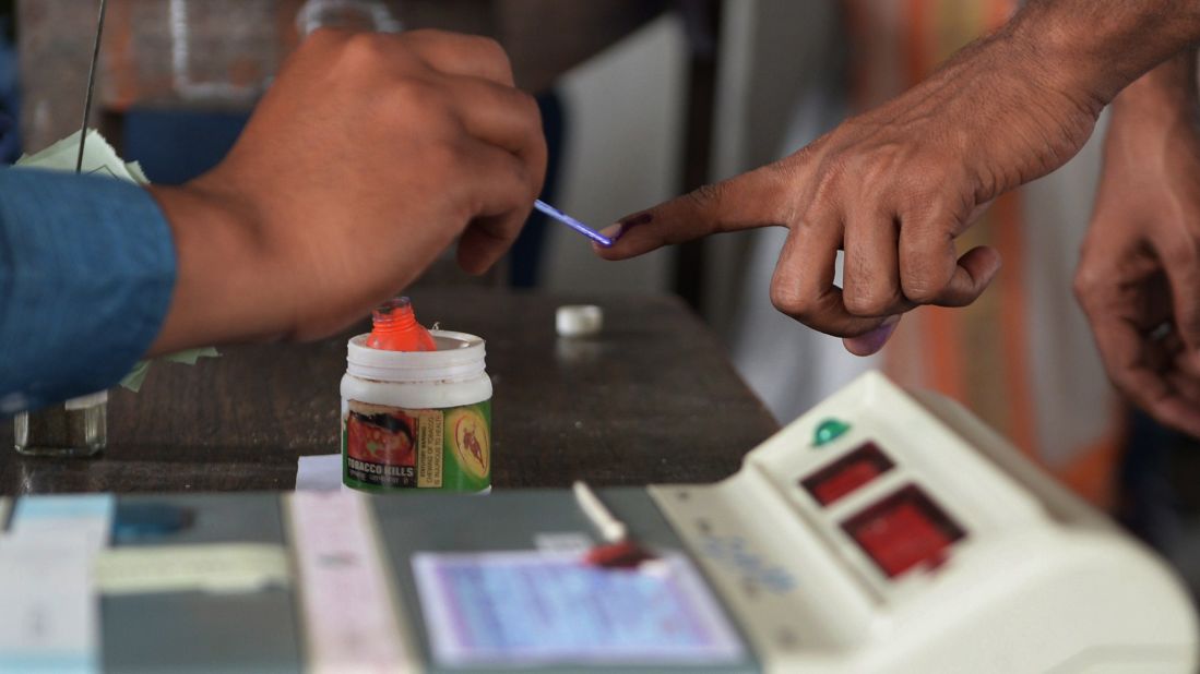 An election officer uses ink to mark a voter's finger at a polling station in Dibrugarh on April 7.