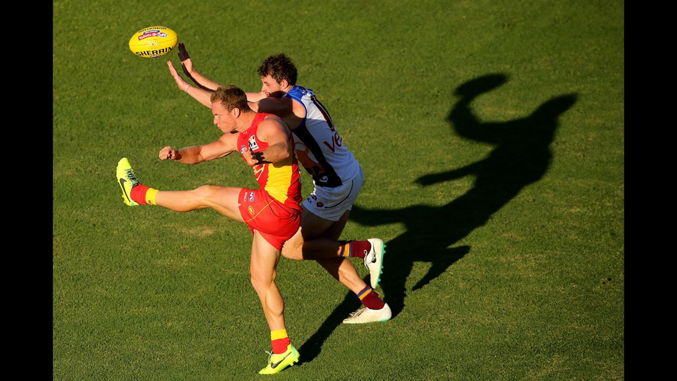 Brendon Matera of the Gold Coast Suns kicks the ball past Pearce Hanley of the Brisbane Lions during an Australian rules football match played Saturday, April 5, in Gold Coast, Australia.