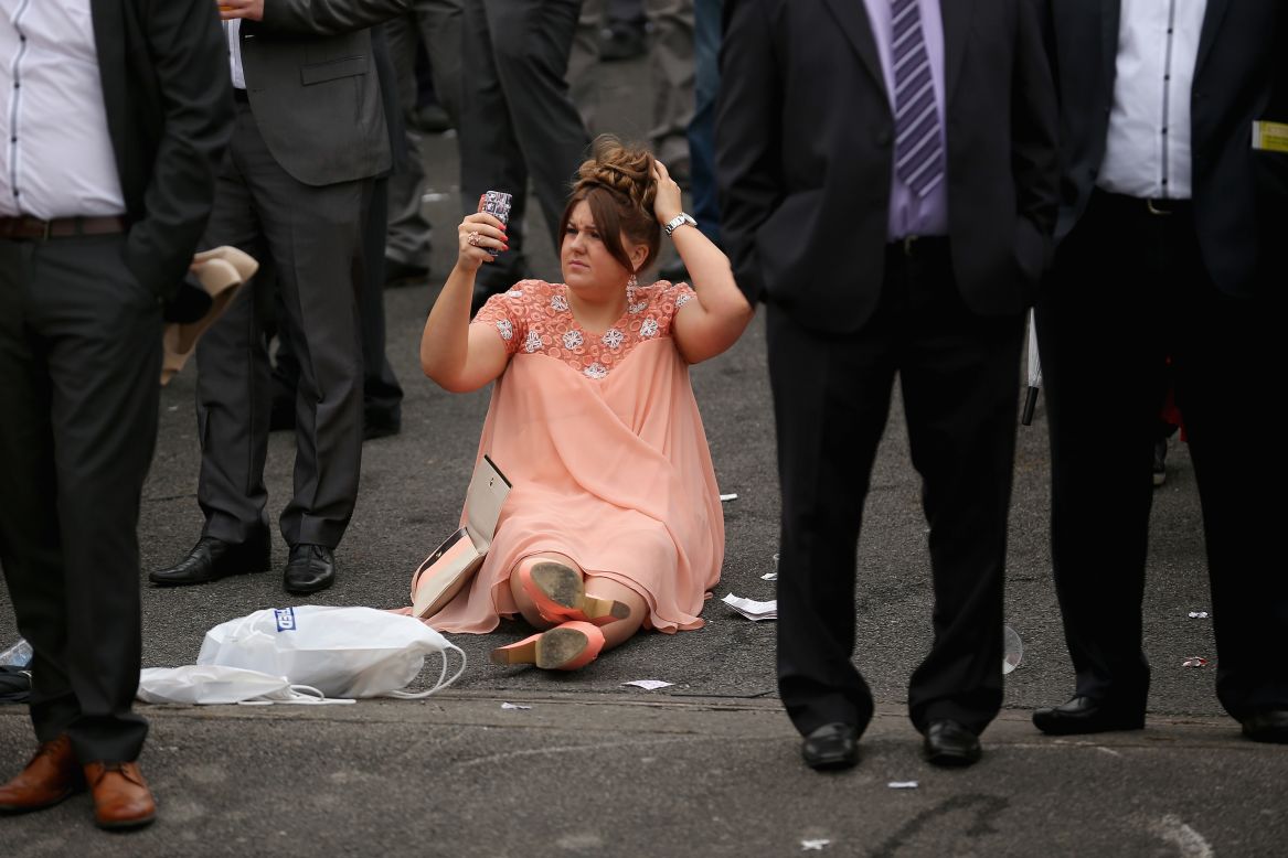 A spectator uses the camera on her cell phone to check her hair on the opening day of the Grand National horse races Thursday, April 3, at Aintree Racecourse in Liverpool, England.