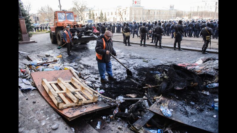 Workers clean up on April 8 after pro-Russian separatists and police clashed overnight in Kharkiv.