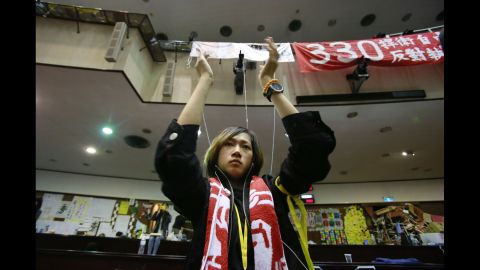 A student protesting a trade pact between Taiwan and China applauds as leaders of the protest speak on the floor of Taiwan's Legislature on Monday, April 7, in Taipei. Protesters, mostly college students, have been camped out in Taiwan's Legislature building since March 18. They say the trade deal with China could harm Taiwan's economy, democratic system and national security. But supporters of the deal have also come out to express themselves.