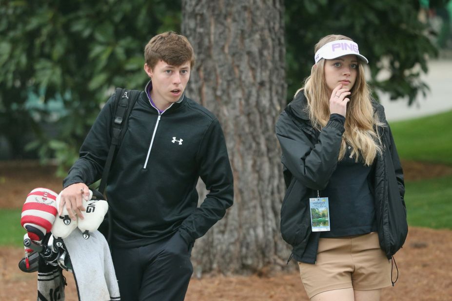 Here he walks with girlfriend Amy during Monday's practice round at Augusta National in Georgia.